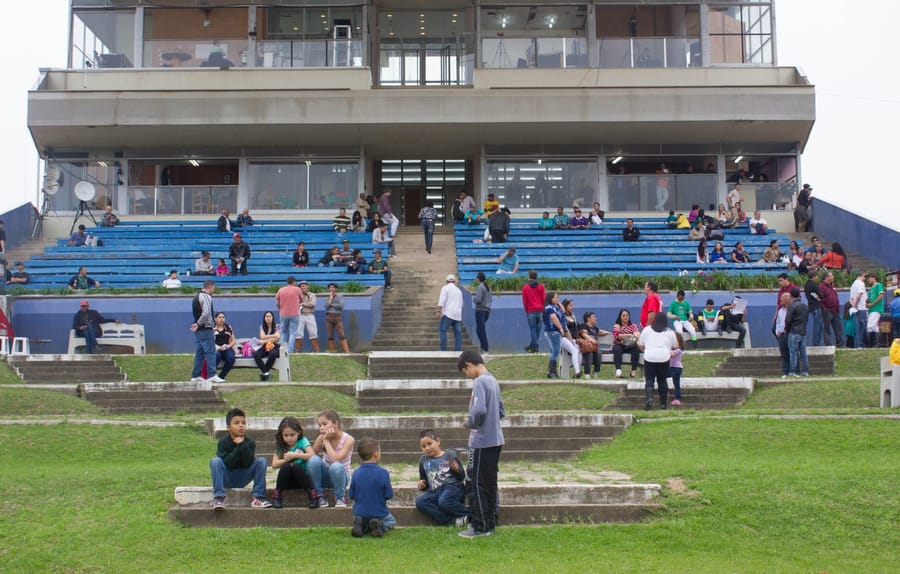 Tribuna do Cristal vista de frente, com arquibancadas azuis e o gramado em degraus